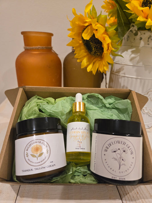Open box with a moisturizing cream, a bottle of body oil, and a charcoal mask