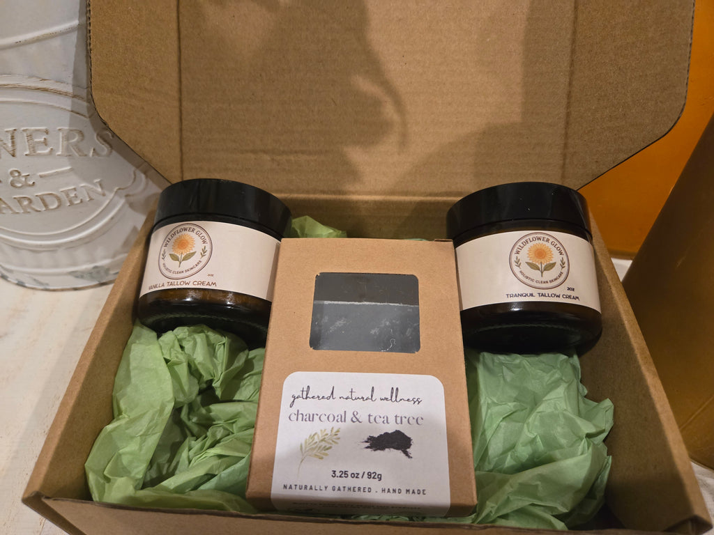 Open box with a vanilla tallow cream, packaged charcoal and tea tree soap bar and a tranquil magnesium tallow cream. 